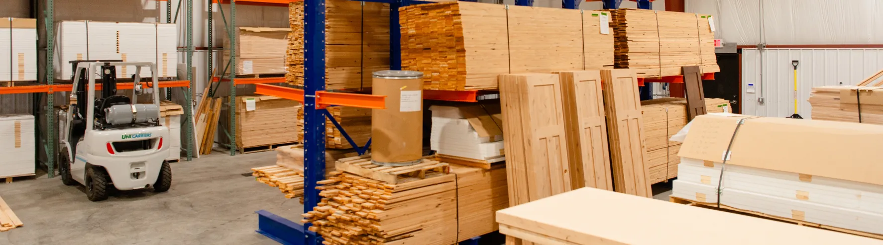 Stacks of custom wood doors and materials in Big Sky Doors’ Montana production warehouse.